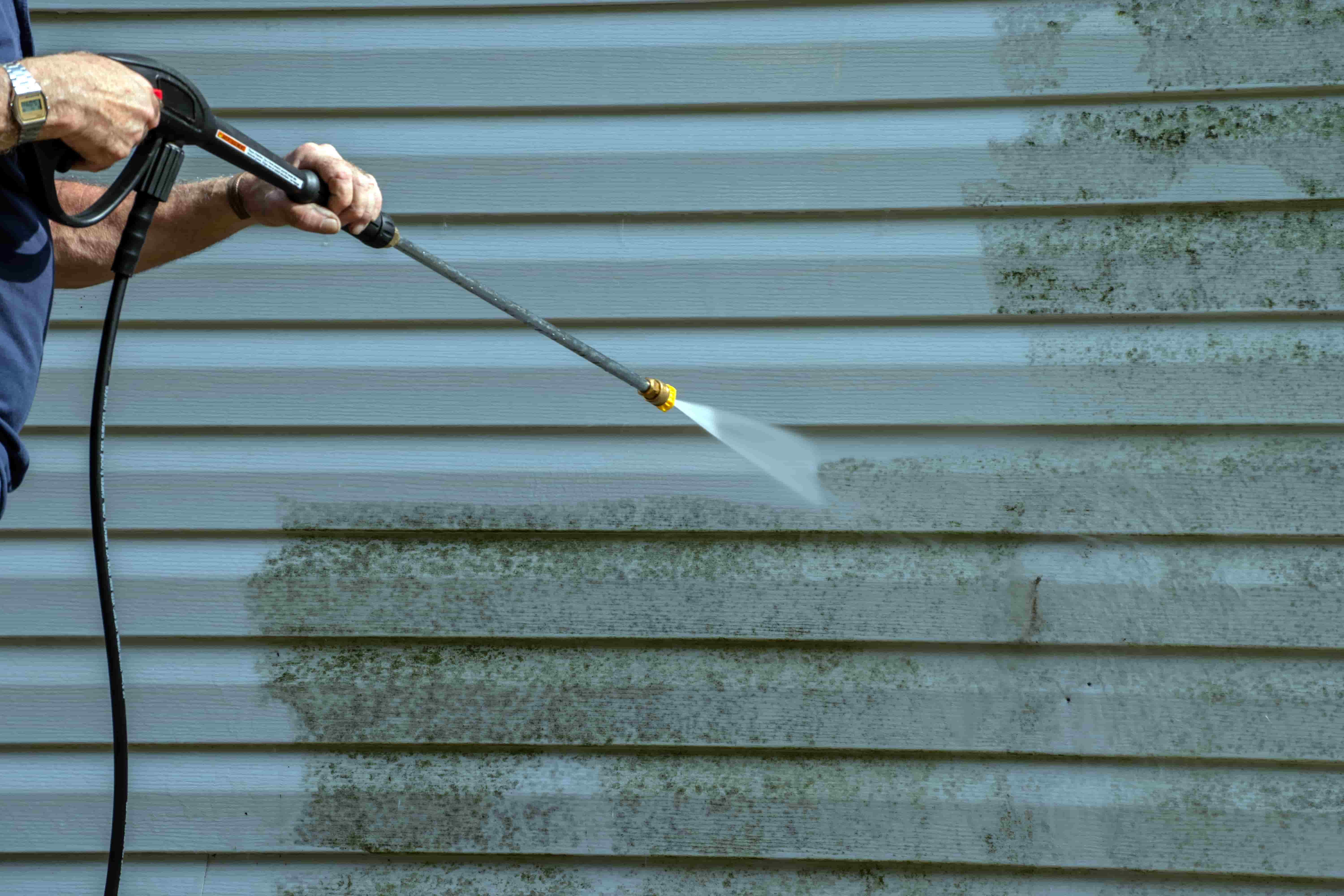 Pressure washing a home exterior surface